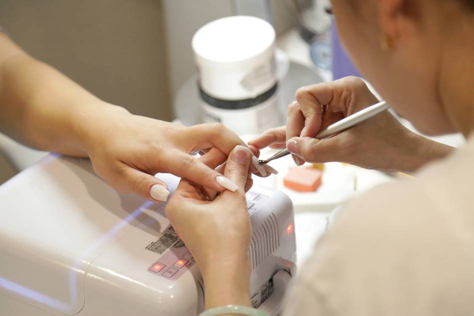 Close-up of professional nail scissors beside natural skincare products